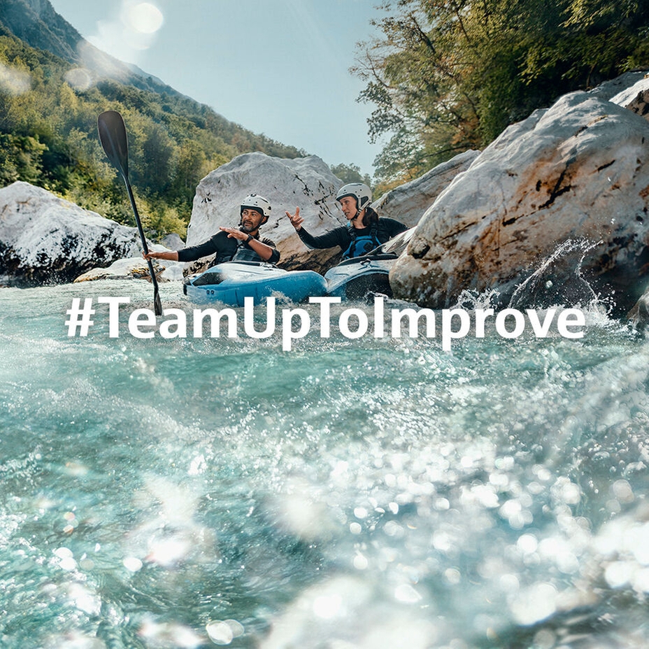Two kayakers overcoming rapids