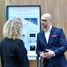 Employee and customer discussing in front of a exhibit at a seminar